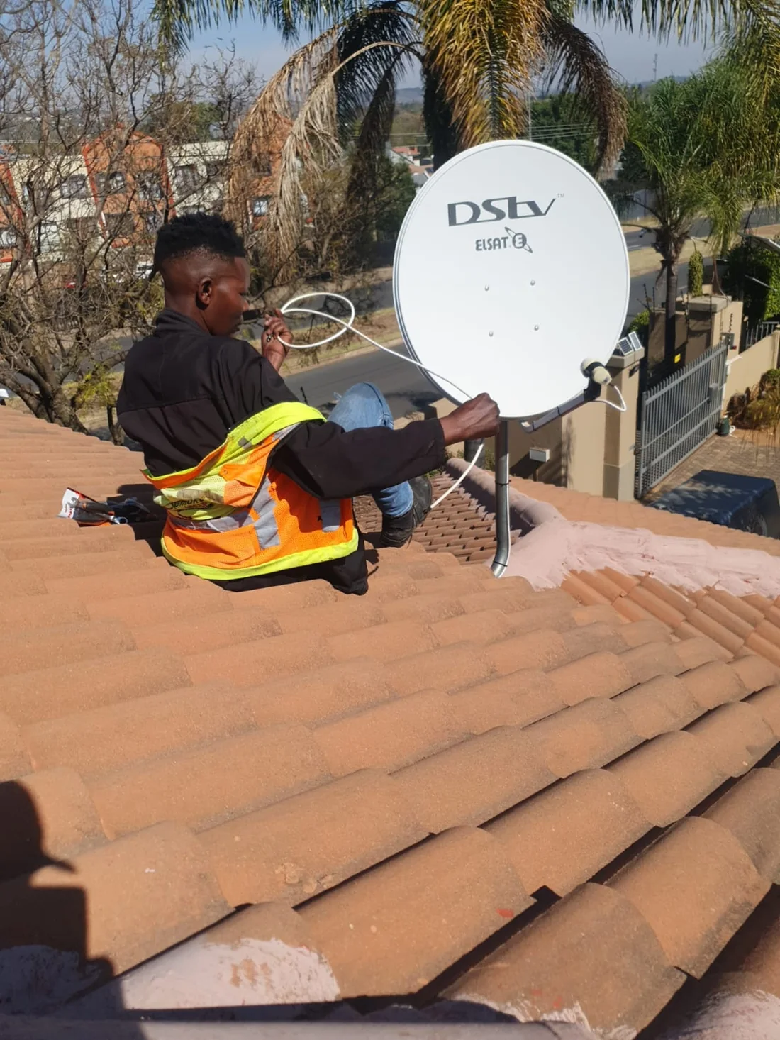 Primed TV installer working on a satellite dish